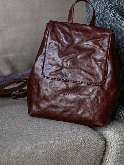 Close detail of the coffee-brown cowhide grain and front flap