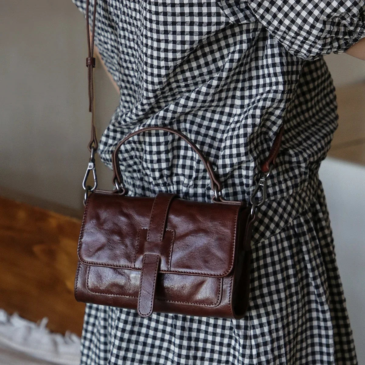 Coffee brown leather mini crossbody bag styled with a gingham dress