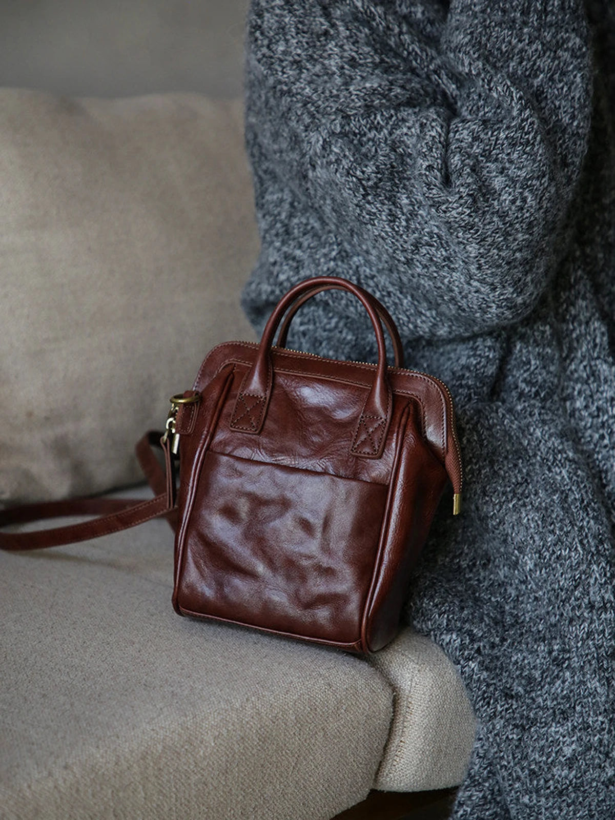 Coffee brown leather mini backpack shown from the front with top handles