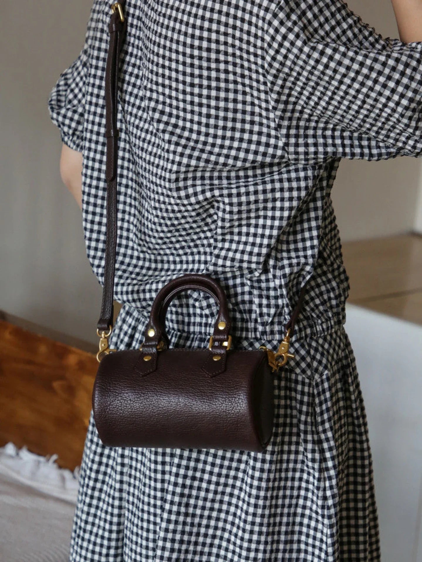 Coffee brown leather barrel bag showing its cylindrical side profile