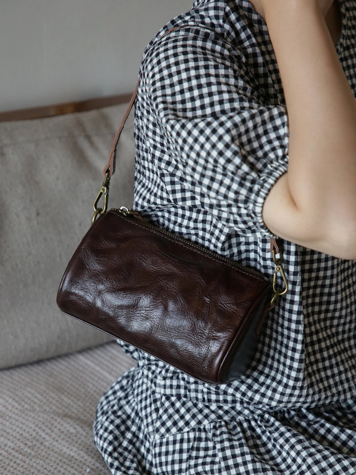Coffee brown leather barrel bag with natural grain and adjustable strap