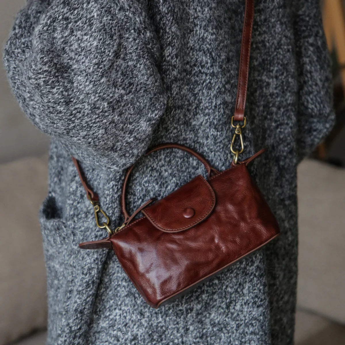 Coffee brown leather mini crossbody bag worn over the shoulder