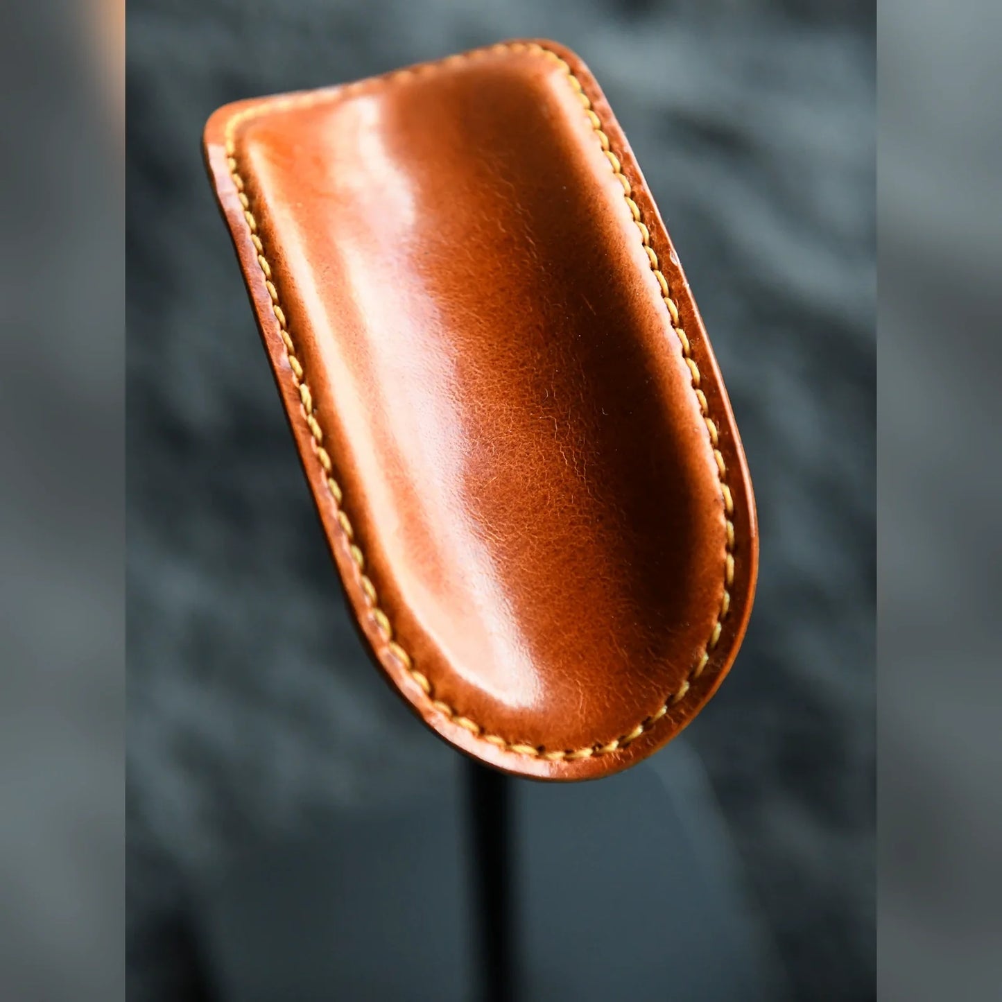 Close-up of tan cowhide cradle and hand stitching