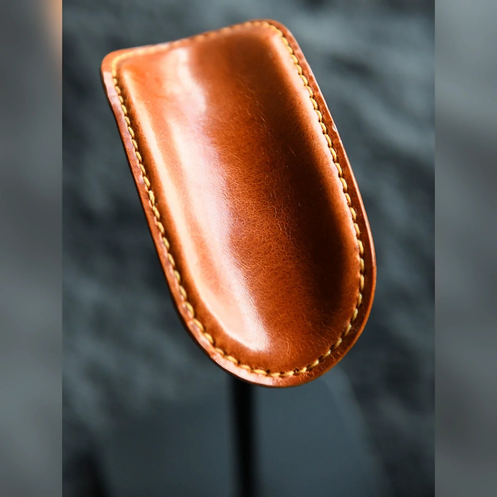 Close-up of tan cowhide cradle and hand stitching
