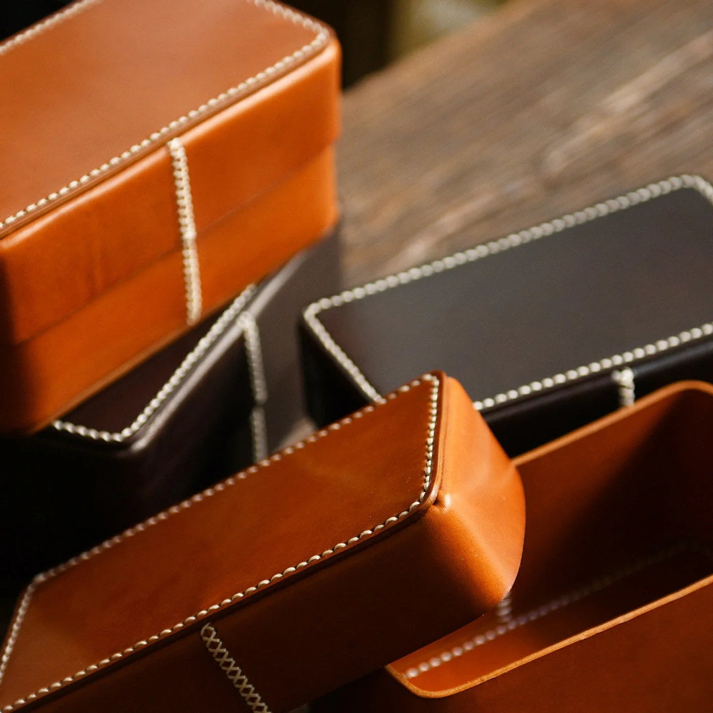 Handcrafted leather storage boxes arranged in multiple shapes and finishes