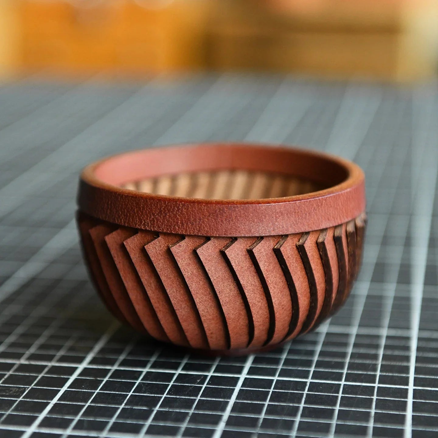 Handcrafted cowhide storage bowl showing the woven side structure