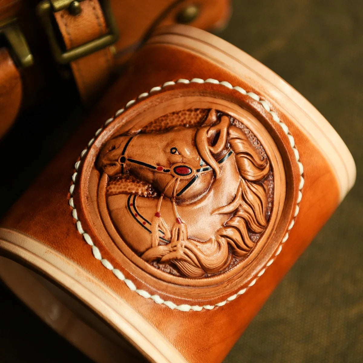 Hand-carved horse medallion detail on vegetable-tanned leather