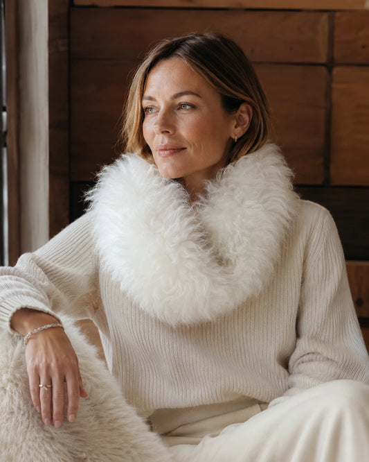 Adult woman wearing an Ivory White genuine lamb fur magnetic scarf in a cabin