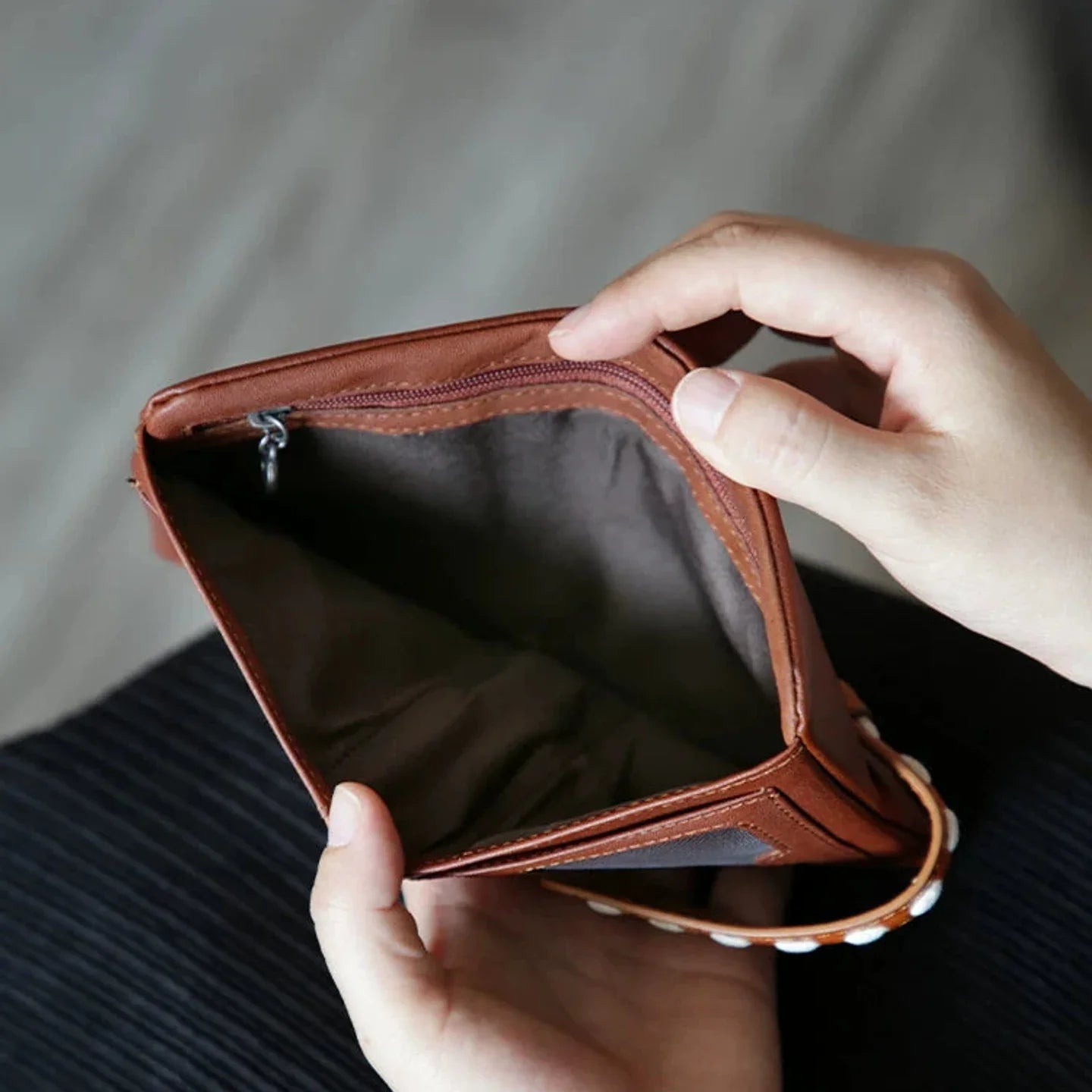 Brown leather wallet opened to show its lined coin compartment