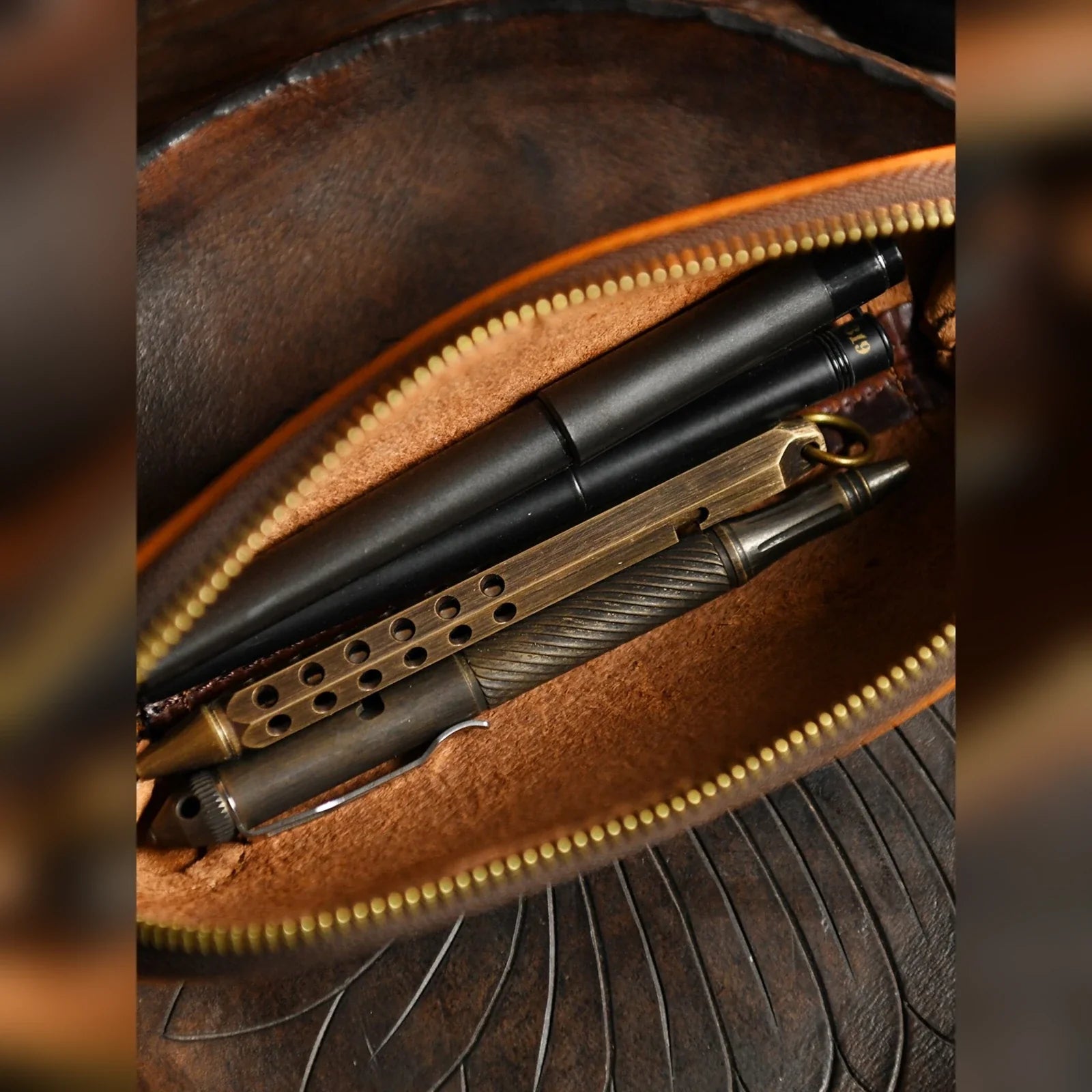 Open leather pencil case holding pens and writing tools