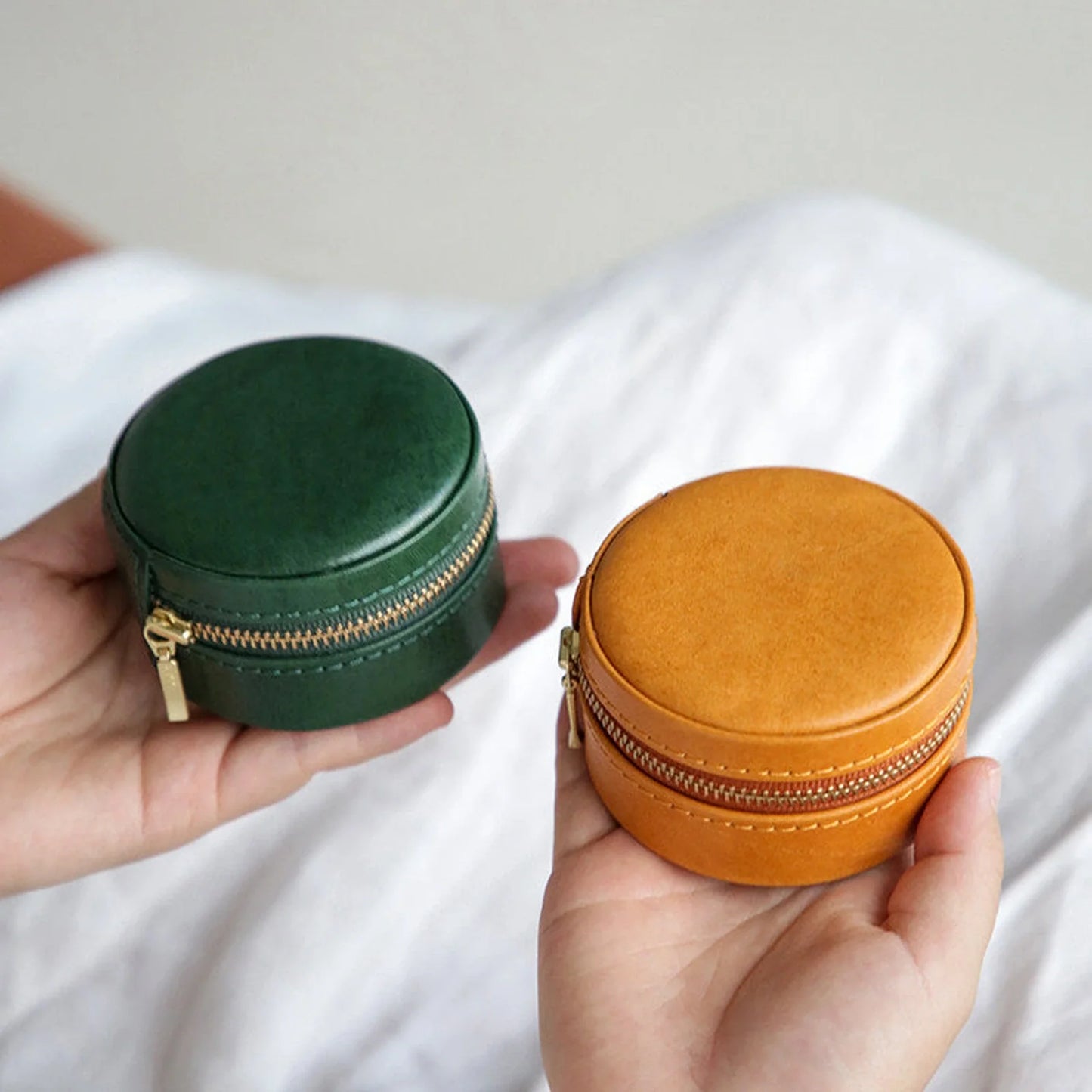 Round leather travel jewelry cases in Forest Green and Sunset Ochre