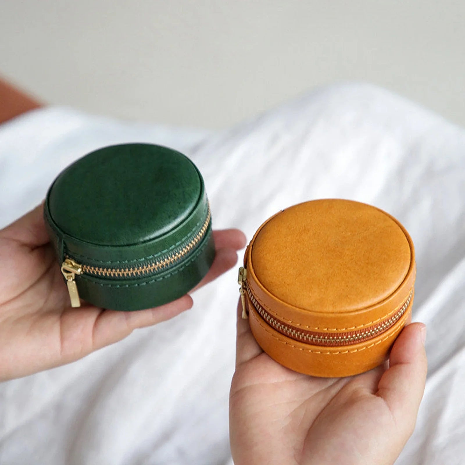 Round leather travel jewelry cases in Forest Green and Sunset Ochre