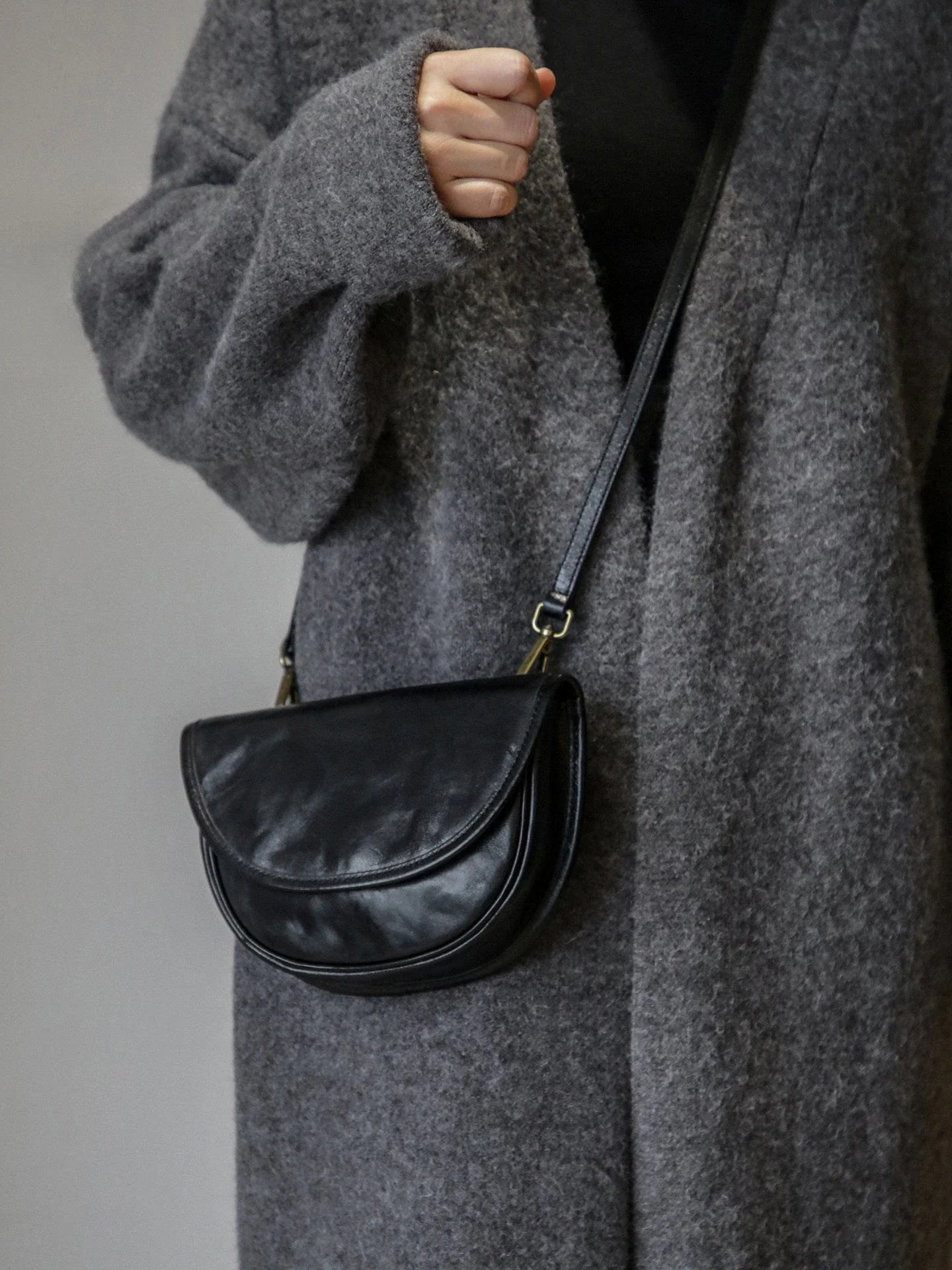Black top-grain cowhide saddle bag worn crossbody