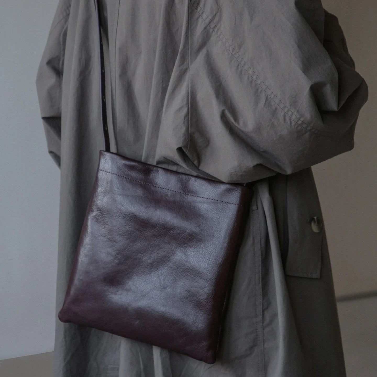 Ebony brown leather bag worn crossbody with an adjustable strap