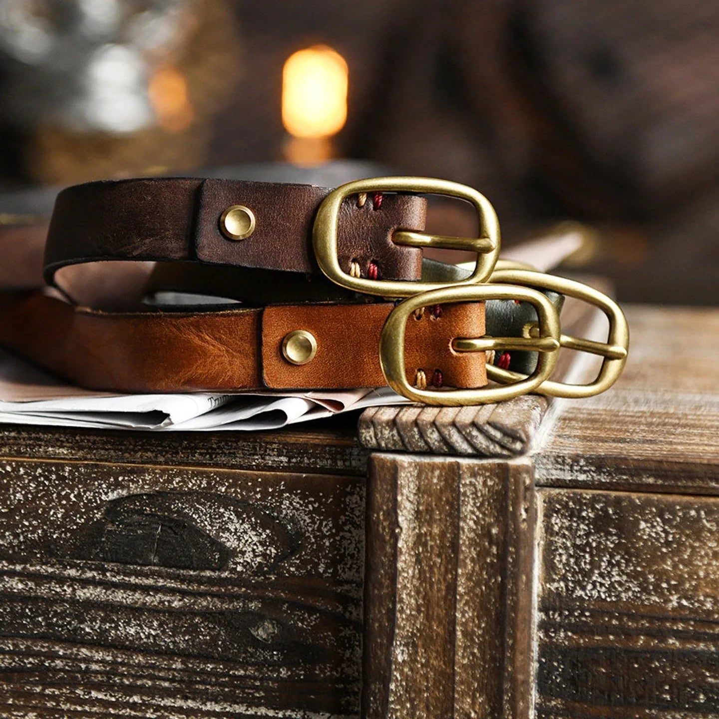 Distressed cowhide belts with oval brass-tone buckles