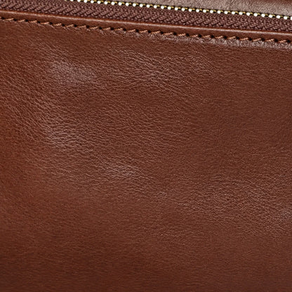 Close-up of brown top-grain leather texture, stitching and zipper