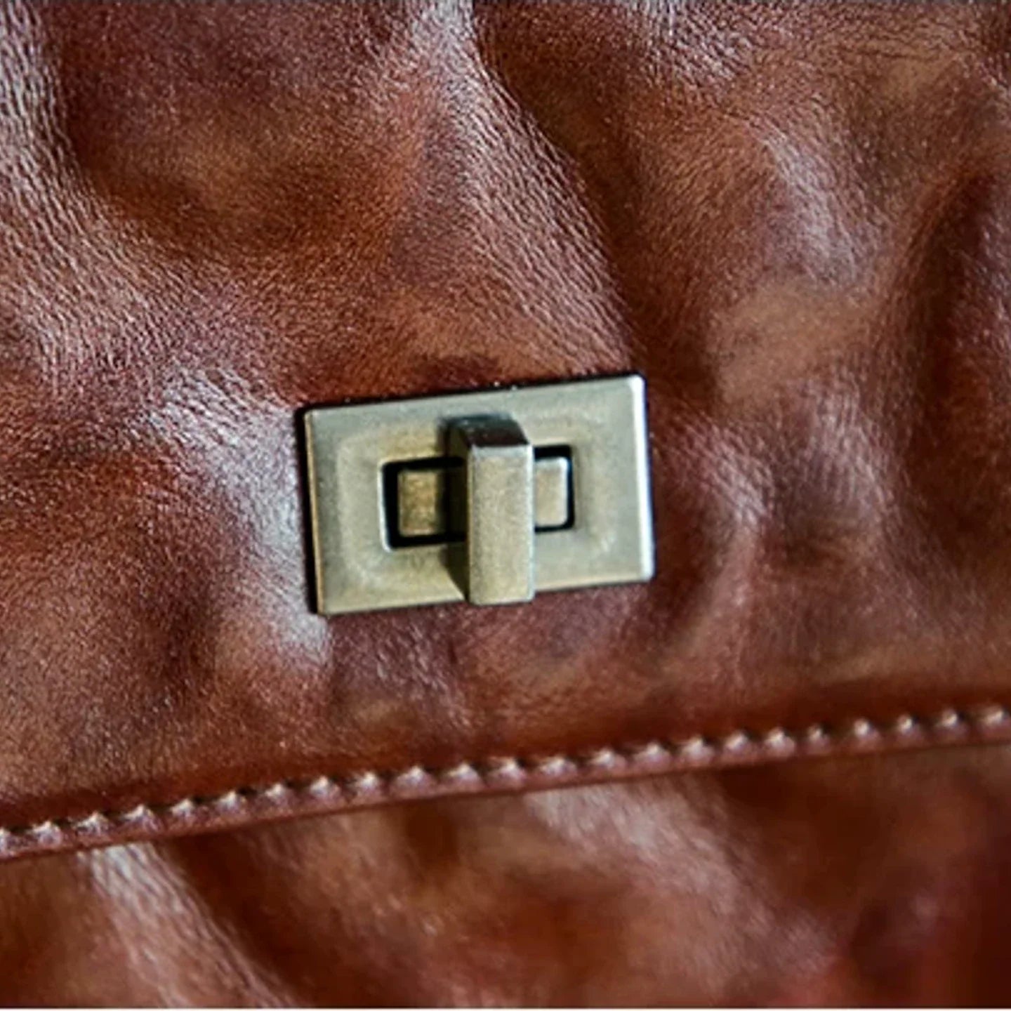 Close-up of the vintage-style turn lock and top-grain leather texture