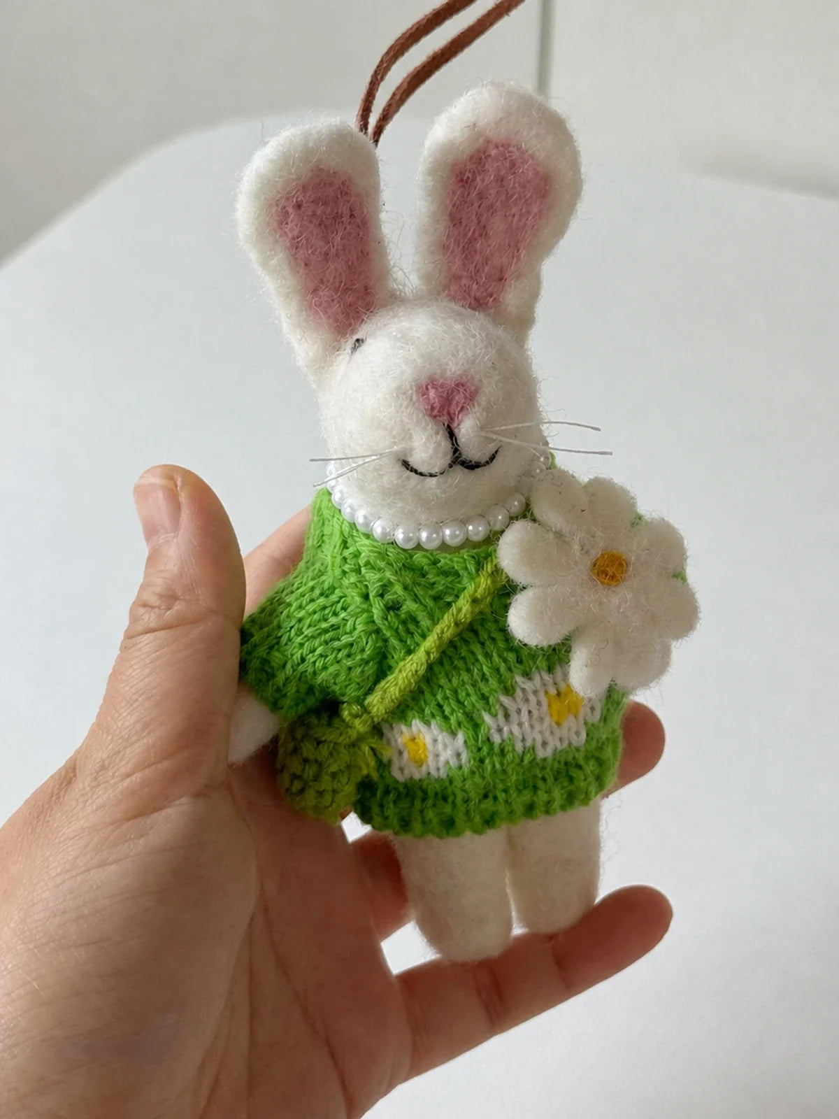 Handheld view of the wool felt rabbit keychain for visual scale