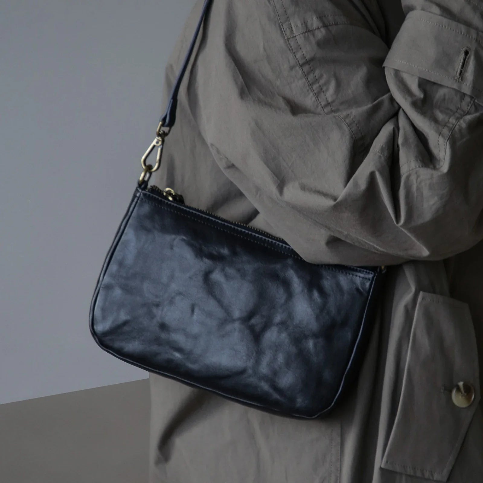 Black crinkle-finish leather shoulder bag worn crossbody