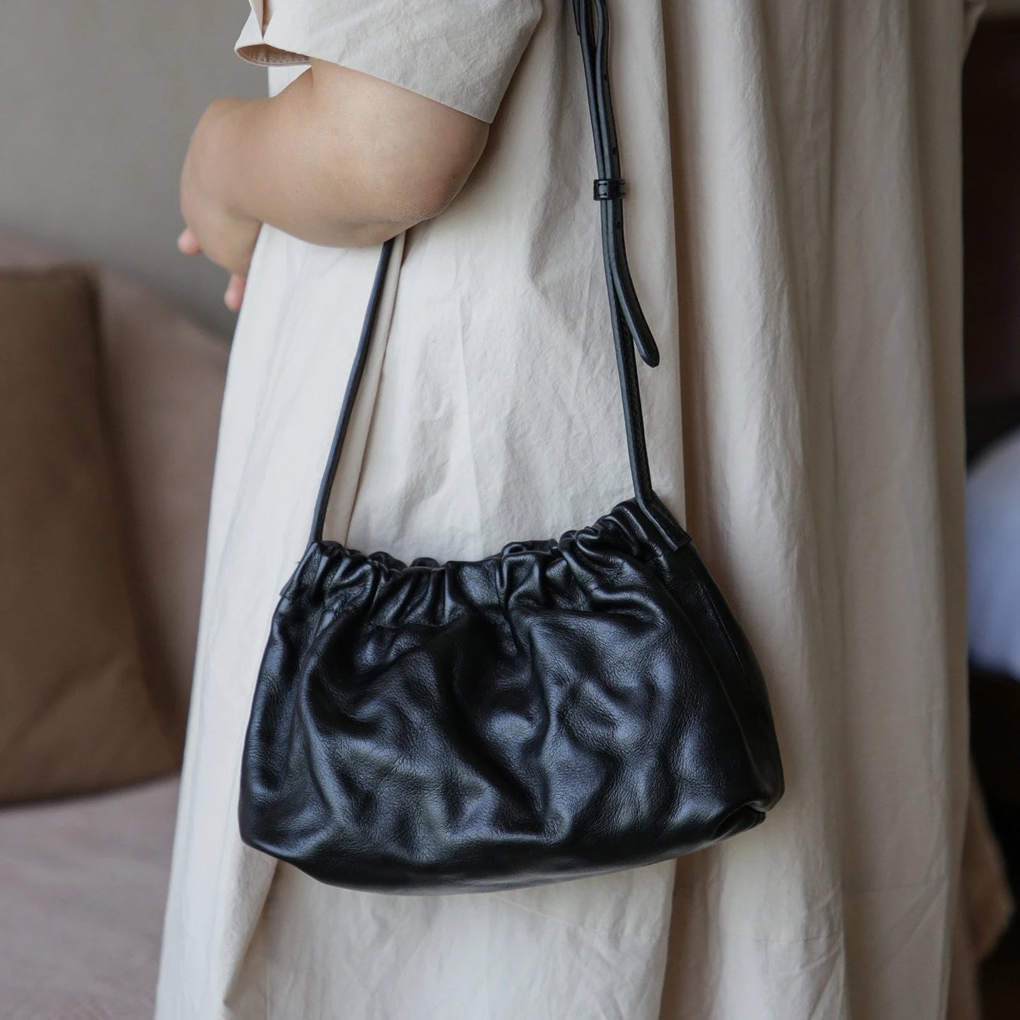 Black ruched leather cloud shoulder bag worn crossbody