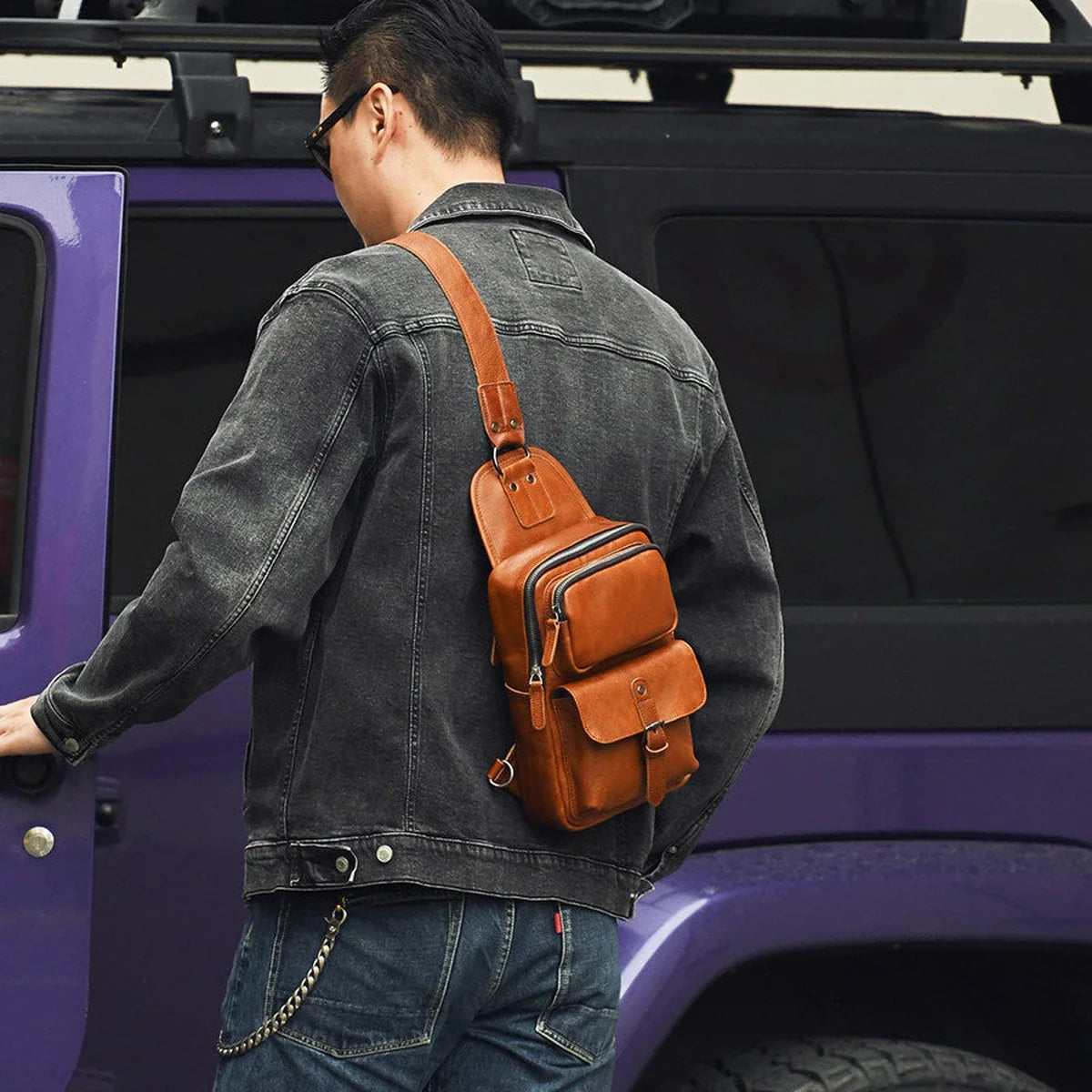 Brown leather sling bag worn on the back for travel