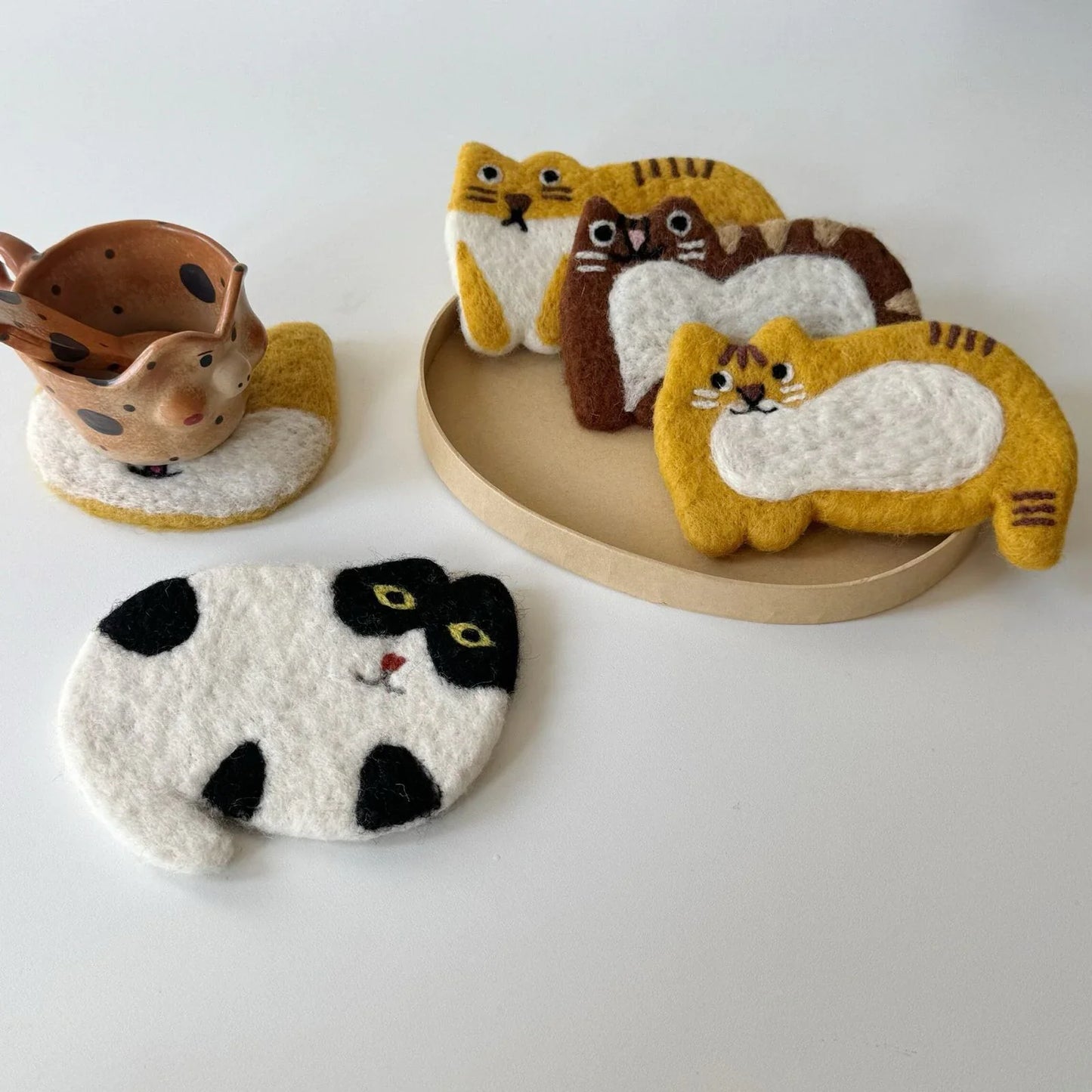 Handmade wool felt cat coasters styled with ceramic cups