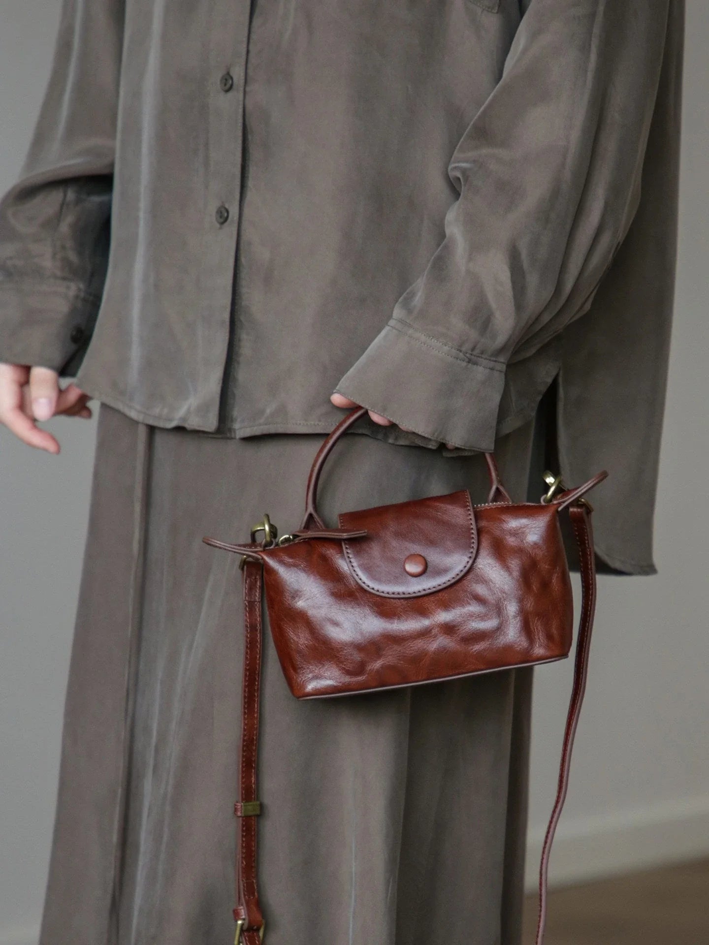 Coffee brown vegetable-tanned leather mini bag carried by the top handle