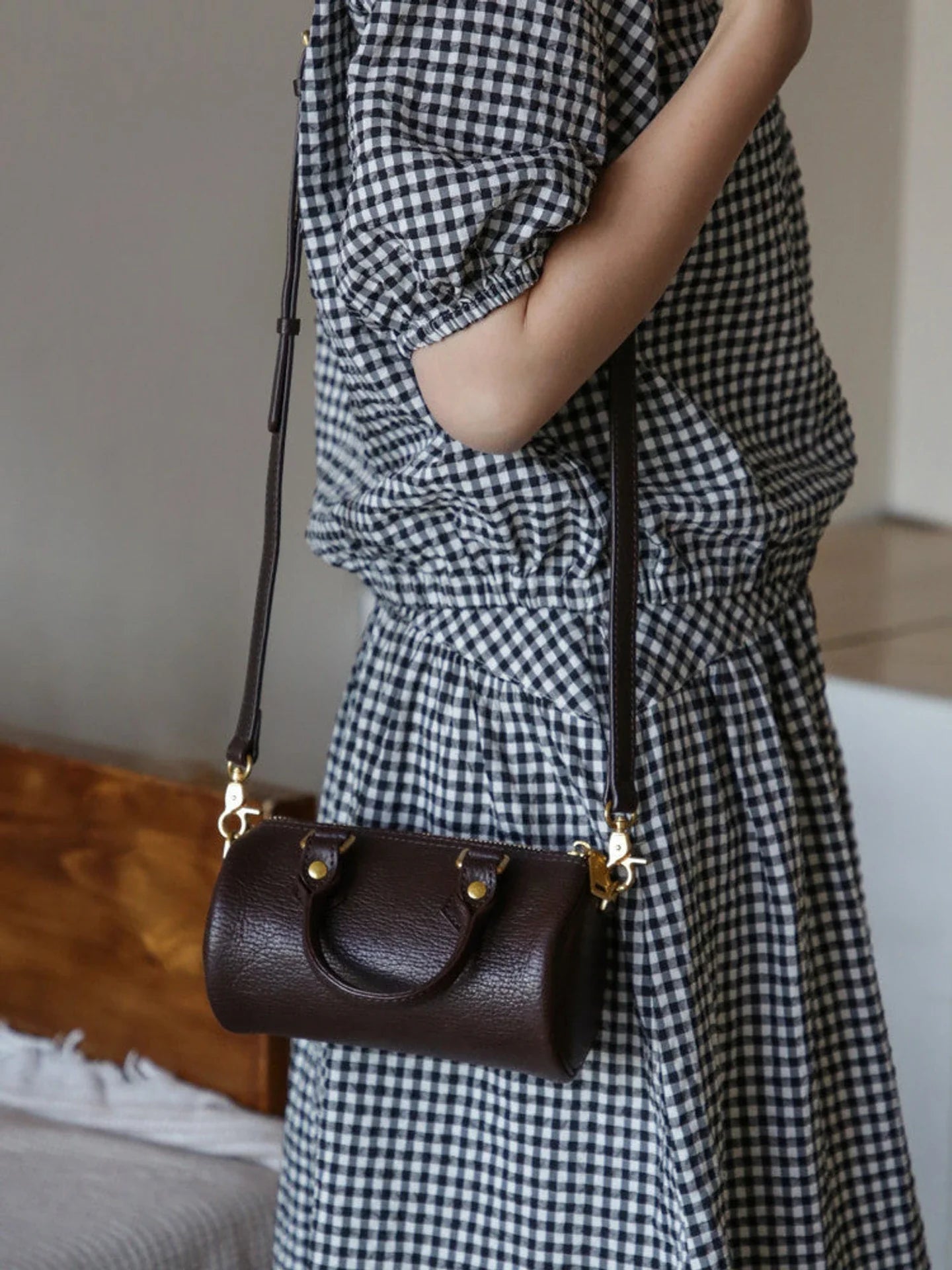 Coffee brown leather barrel bag with curved top handles and long strap
