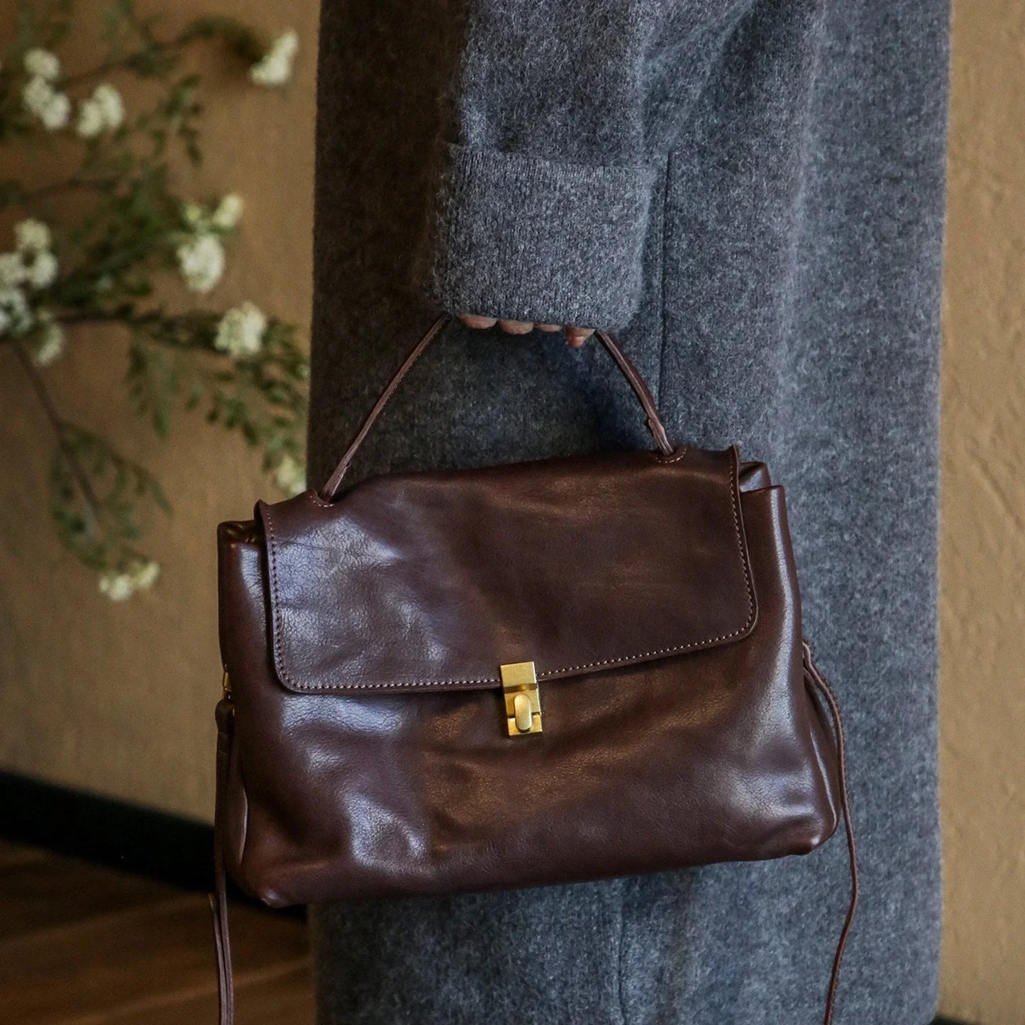 Coffee Brown leather tote bag carried by the top handle