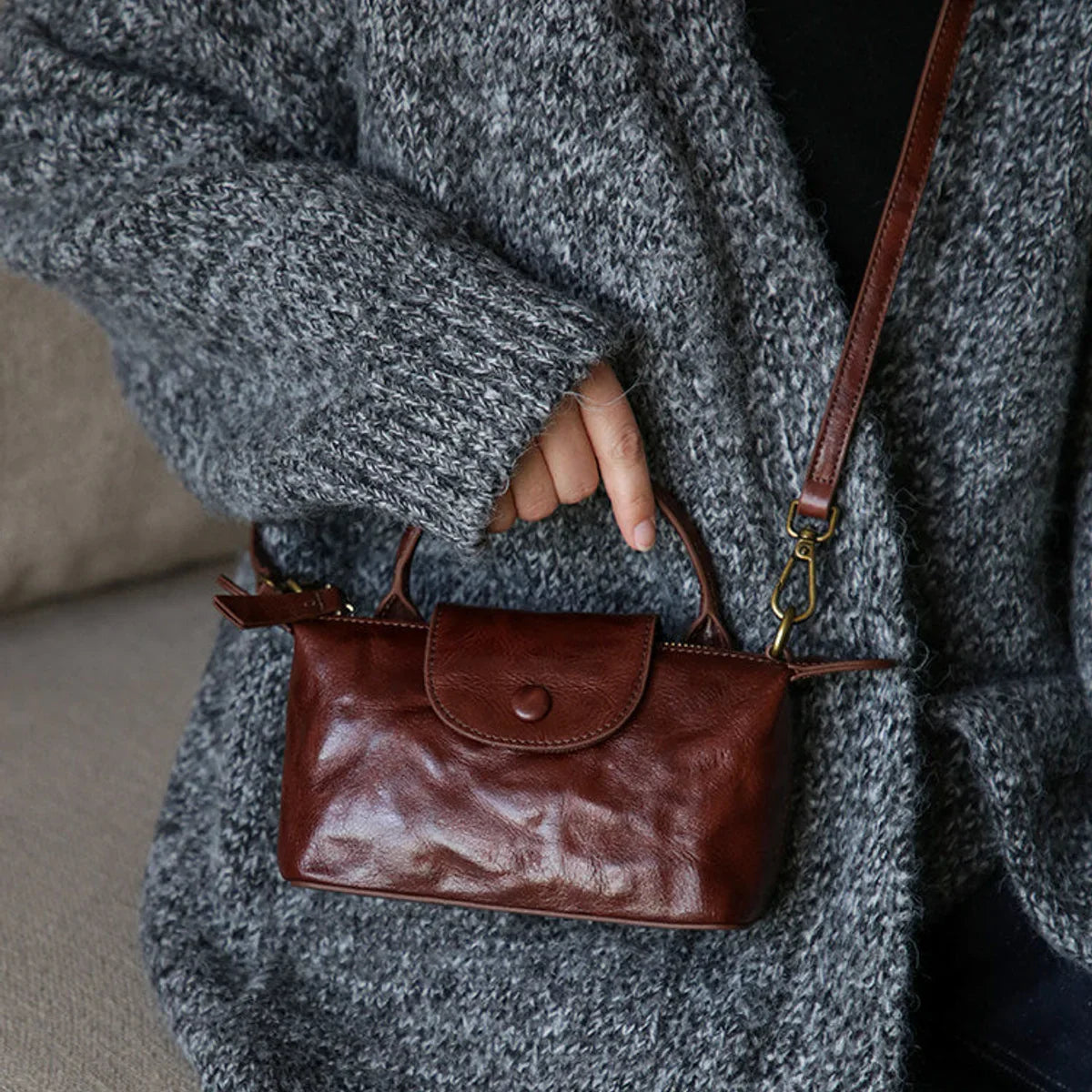 Coffee brown leather mini phone bag shown at an everyday scale
