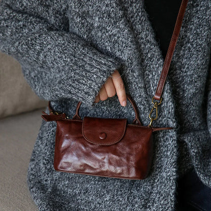 Coffee brown leather mini phone bag shown at an everyday scale