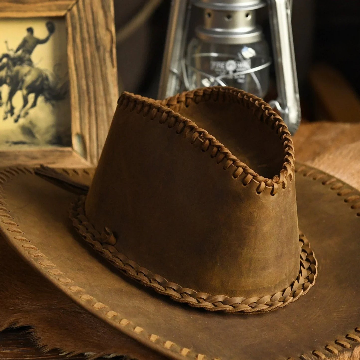 Close view of the cowhide leather grain, braided hatband and hand-stitched edging