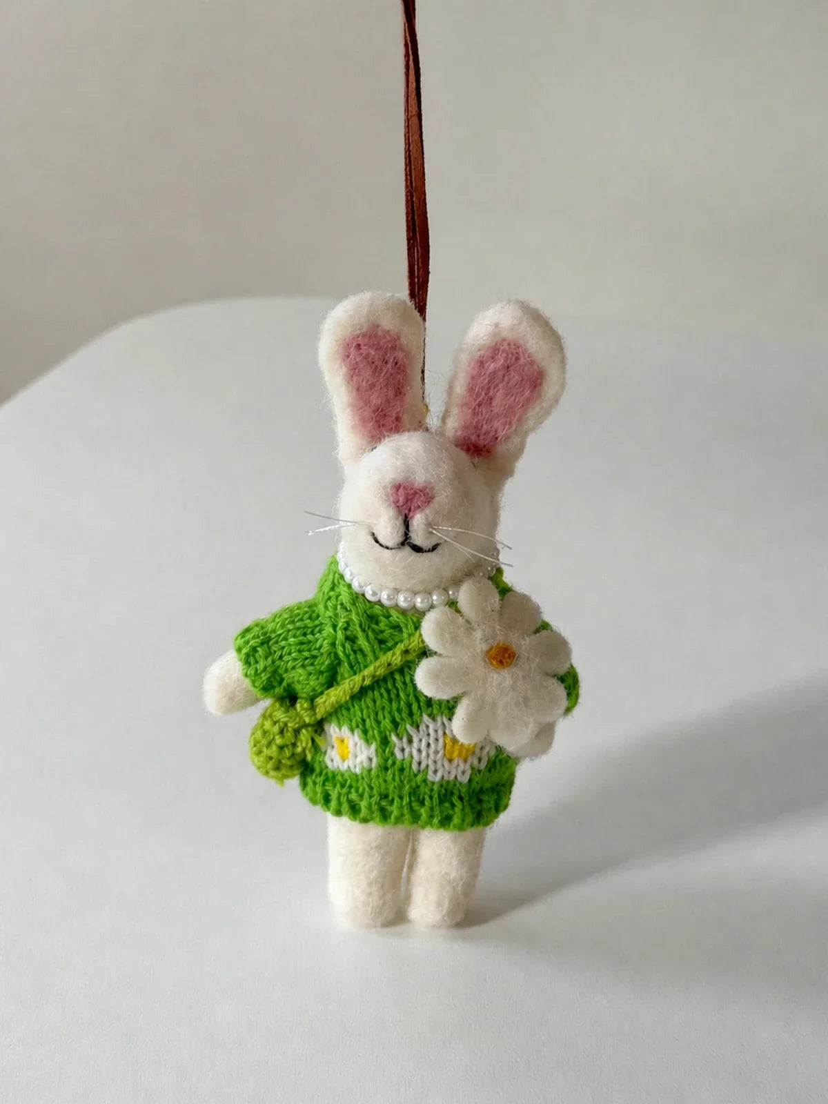 Full hanging view of the handmade rabbit ornament with leather cord