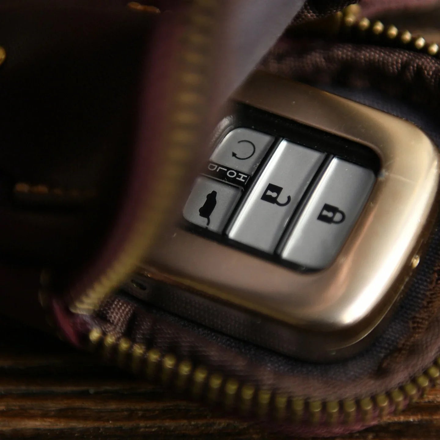 Open leather car key case holding a vehicle key fob