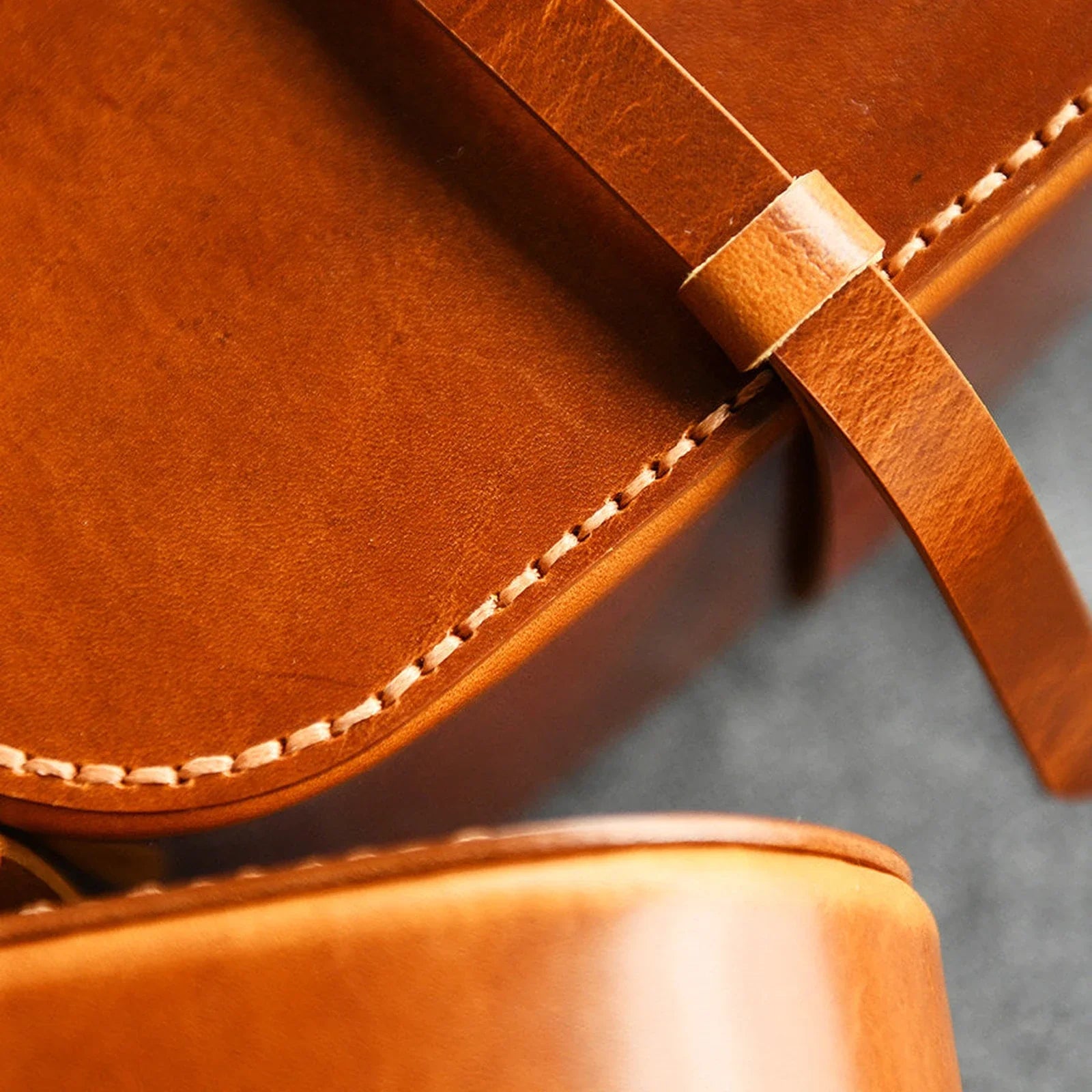 Close detail of leather grain, hand stitching, and wrap strap