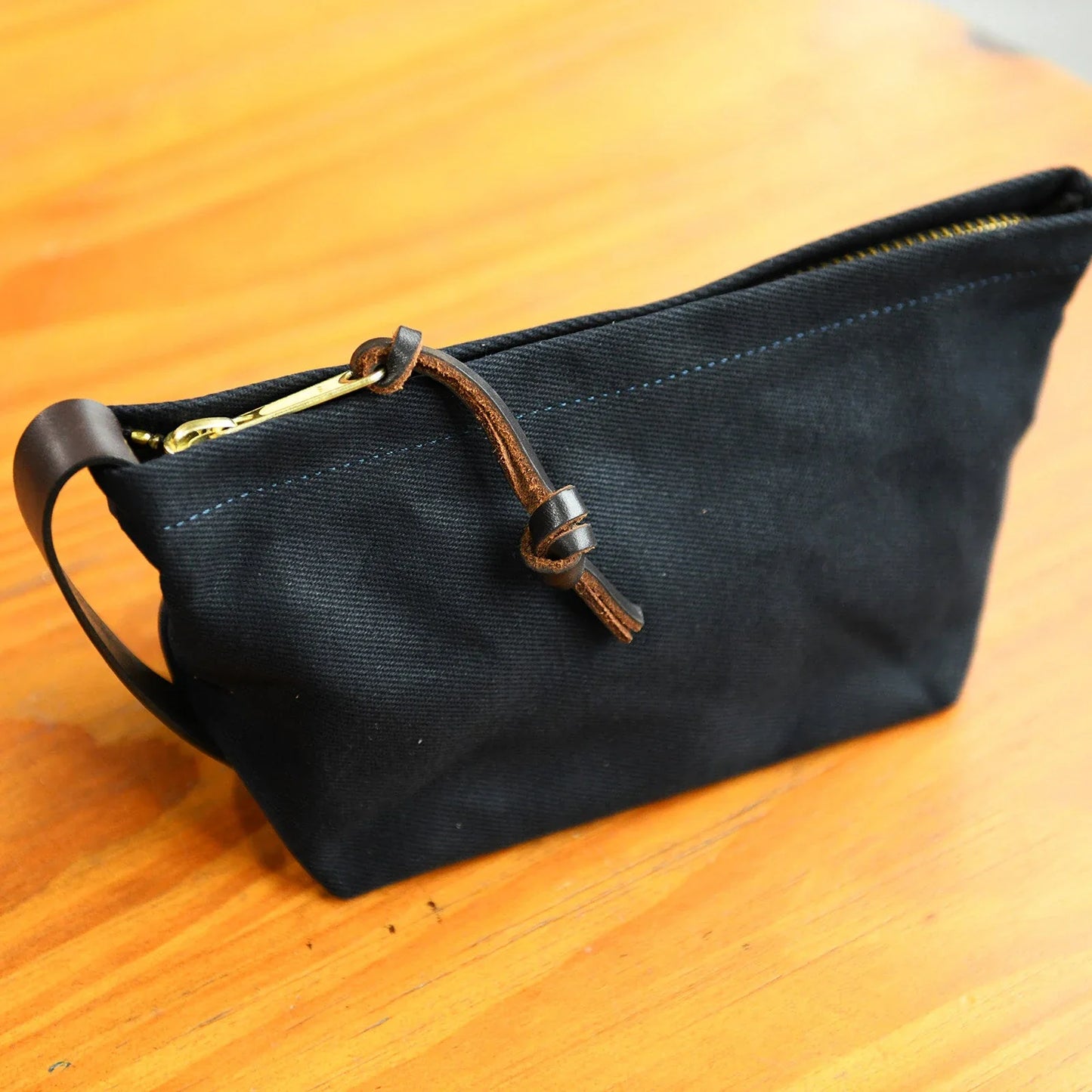 Dark navy waxed canvas travel pouch with zip closure
