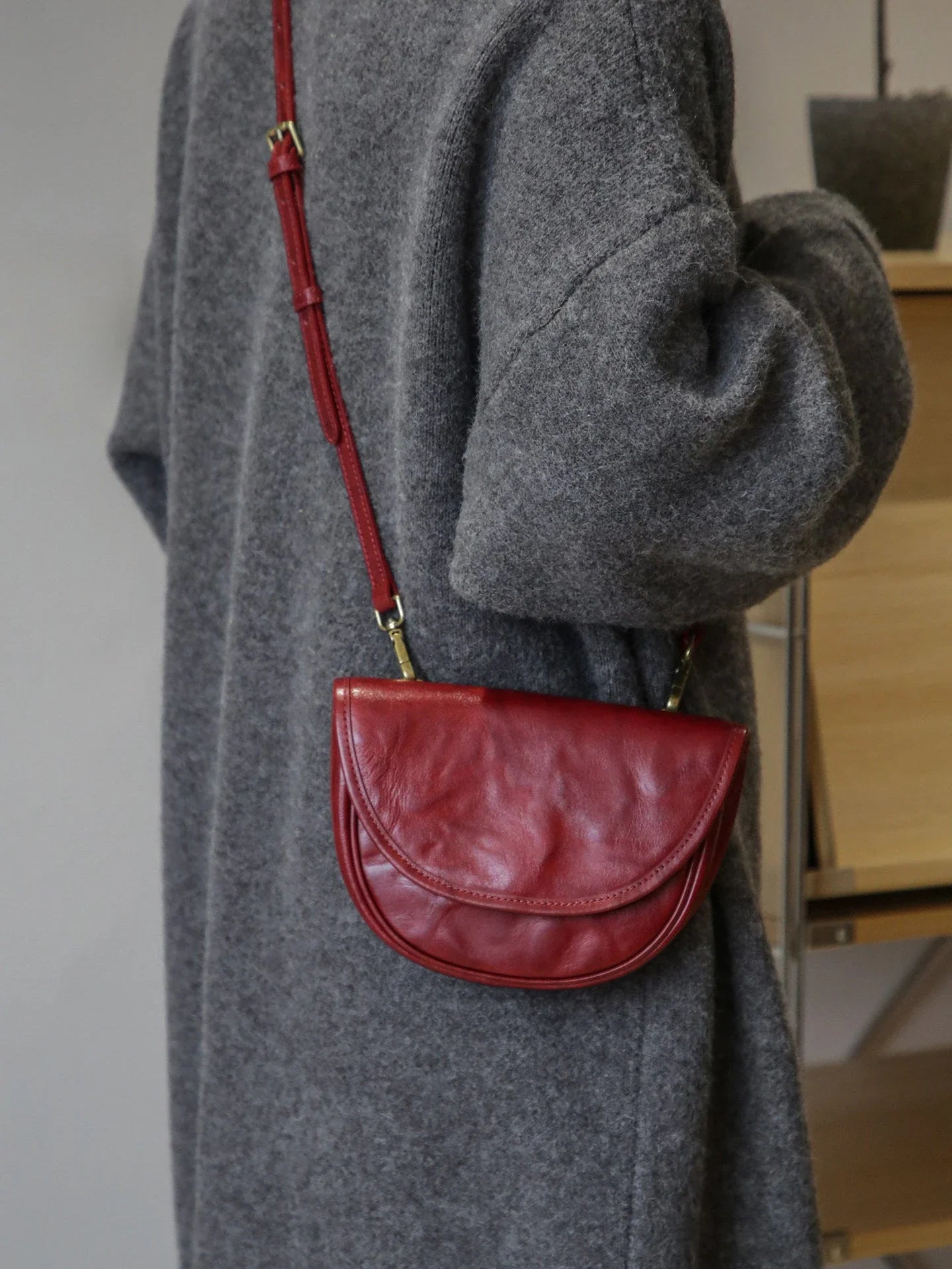 Vintage red saddle bag showing its curved flap and single strap