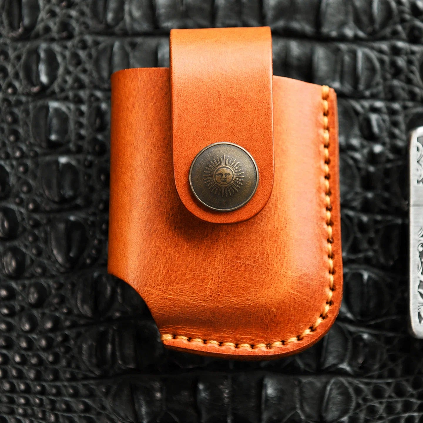 Close-up of top-grain cowhide, edge stitching and metal snap