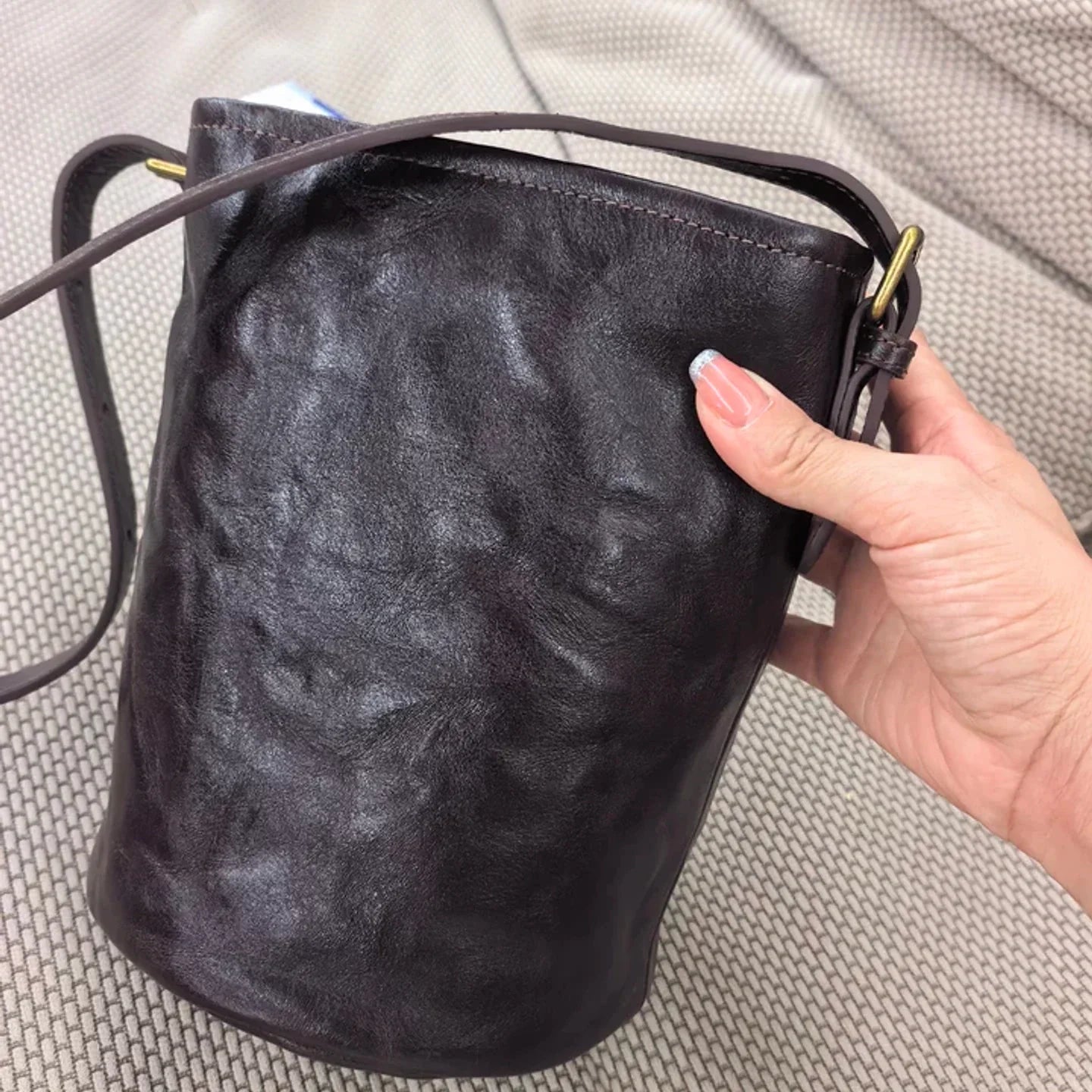 Close view of the ebony brown leather surface and drawstring opening