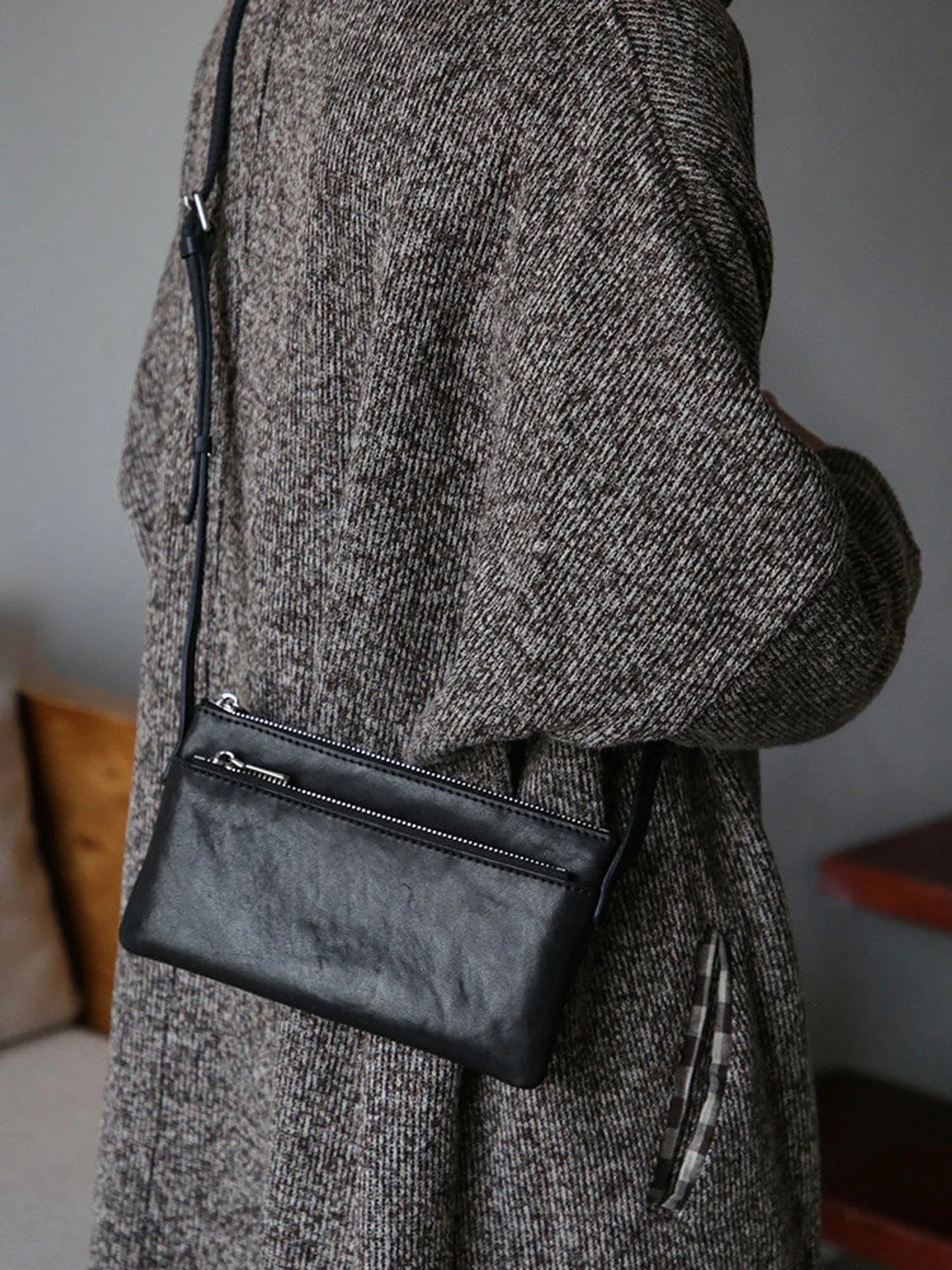 Black top-grain leather slim phone bag worn crossbody