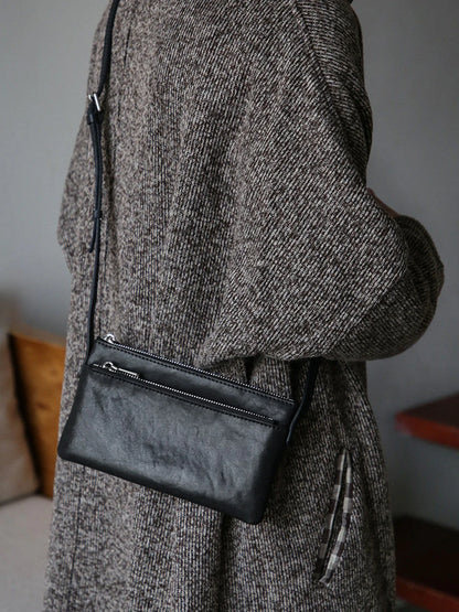 Black top-grain leather slim phone bag worn crossbody