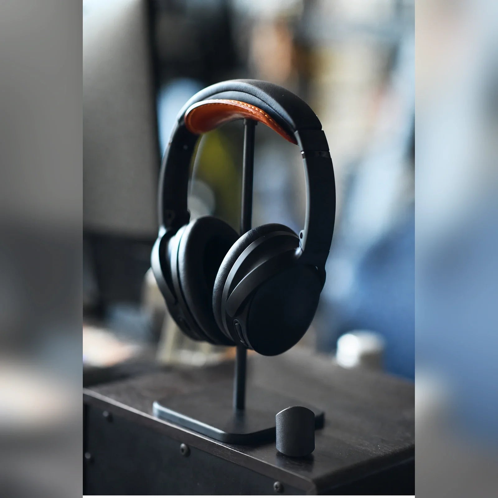Headphones displayed on tan cowhide headphone stand in a studio setting