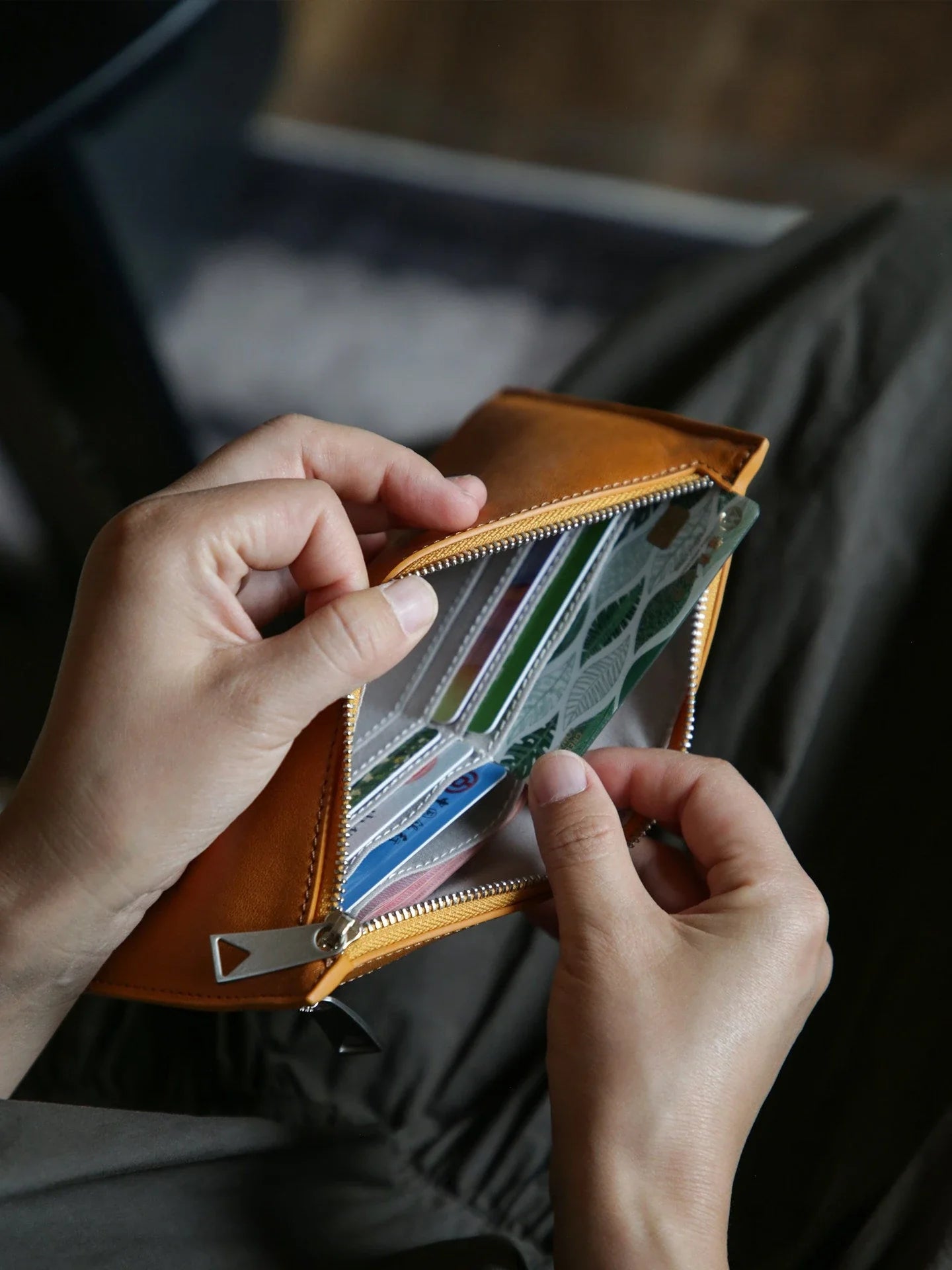 Open leather long wallet with cards arranged inside the zip compartment