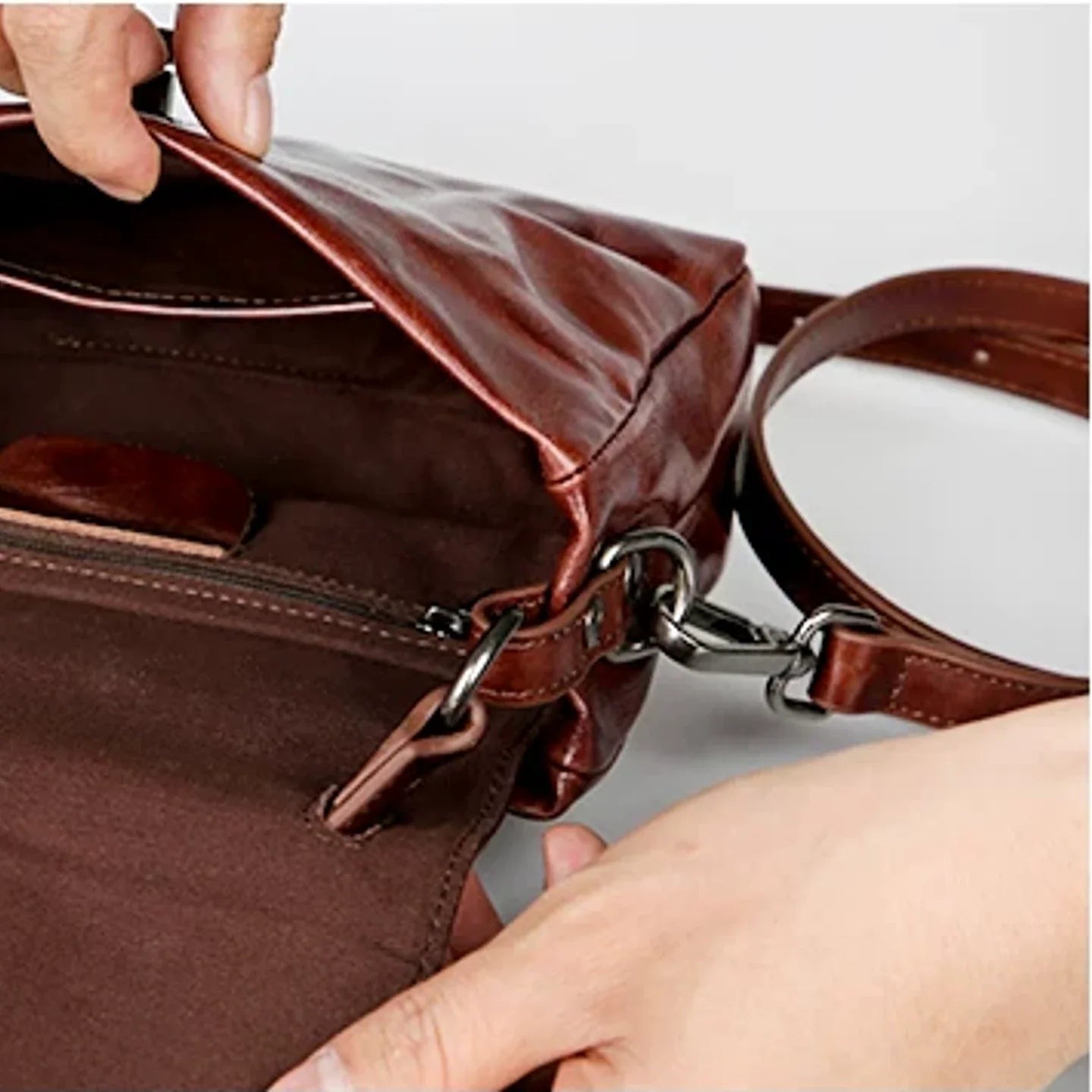 Open leather satchel showing cotton lining and interior pockets