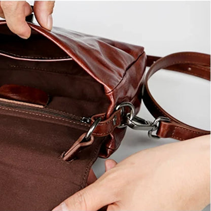 Open leather satchel showing cotton lining and interior pockets