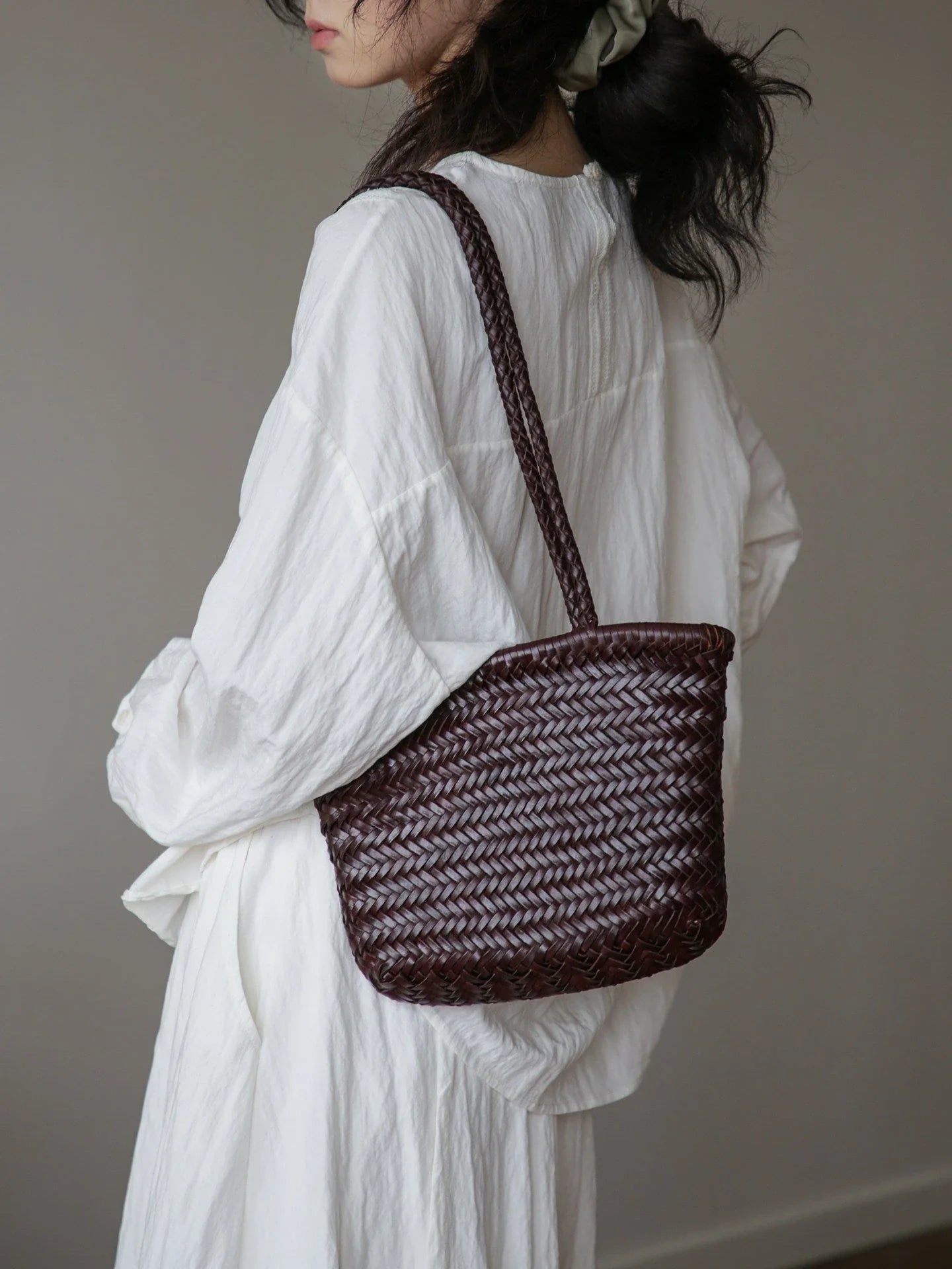 Coffee brown woven leather shoulder bag worn over the shoulder