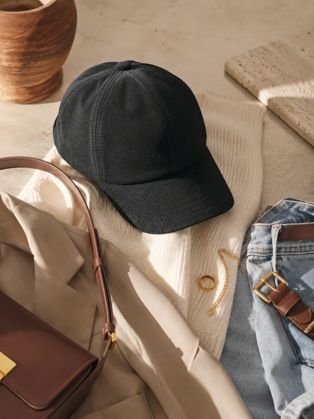 Black suede lambskin beret cap styled with ivory knitwear, denim and a brown bag