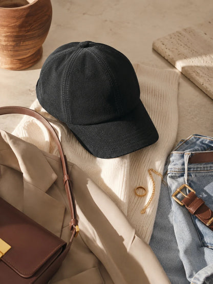 Black suede lambskin beret cap styled with ivory knitwear, denim and a brown bag