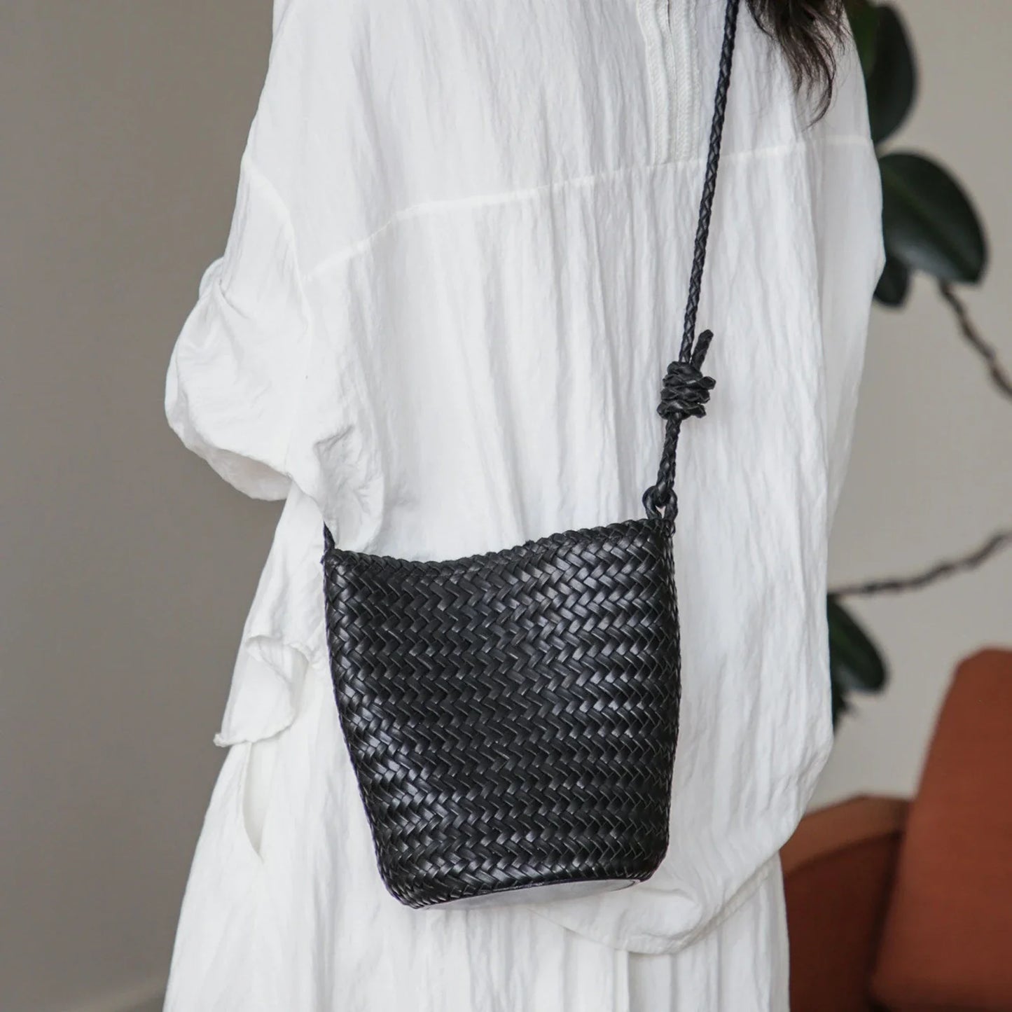 Black woven leather bucket bag styled crossbody