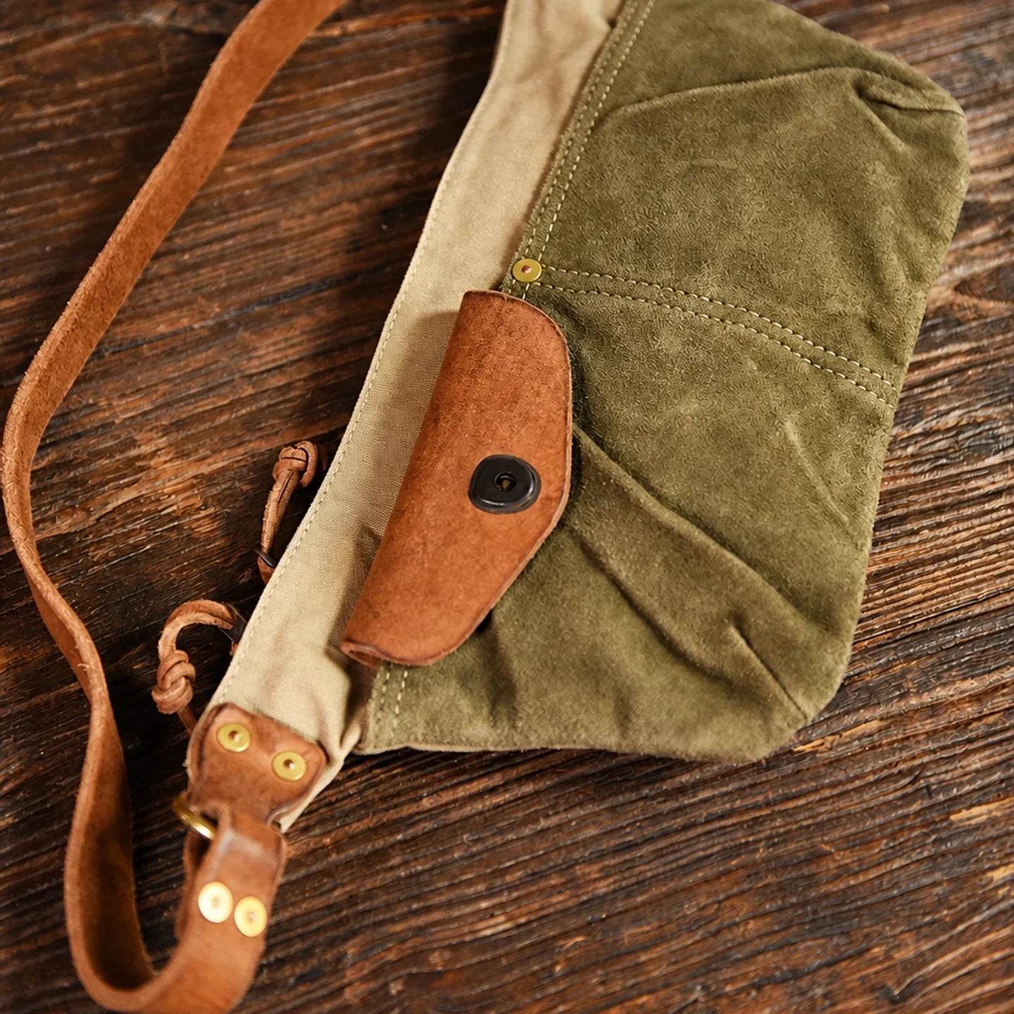 Canvas sling bag construction with adjustable strap and metal hardware